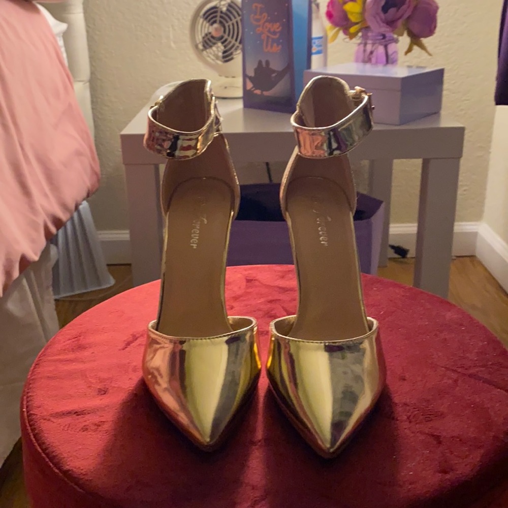 Gold ankle strap stiletto shoes.
